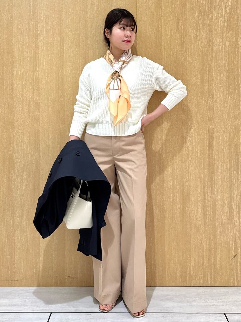 ホワイト系のニット/セーター、ベージュ系のその他パンツ、ブルー系のトレンチコートを着用したレディースの冬コーディネートの2枚目の写真