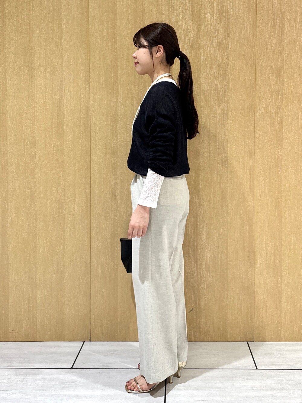 ブルー系のニット/セーター、ホワイト系のカーディガン/ボレロ、ベージュ系のその他パンツを着用したレディースの春コーディネートの2枚目の写真