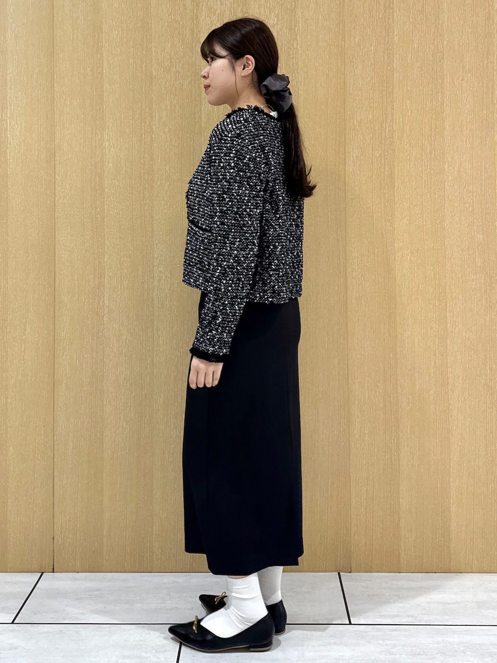 ブラック系のカーディガン/ボレロ、ホワイト系のTシャツ/カットソー、ブラック系のスカートを着用したレディースの秋コーディネートの3枚目の写真