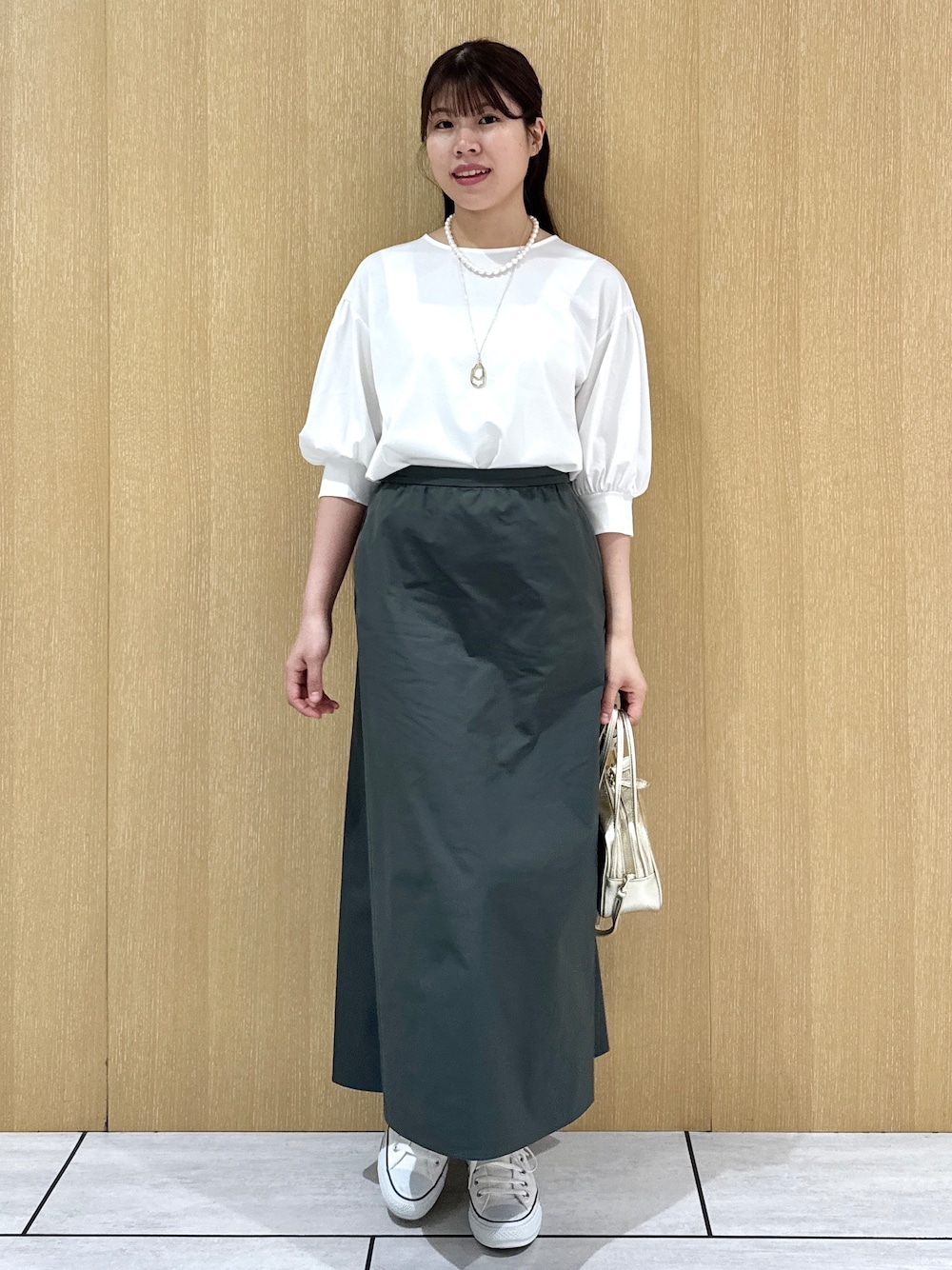 ホワイト系のTシャツ/カットソー、グリーン系のスカートを着用したレディースの秋コーディネートの8枚目の写真