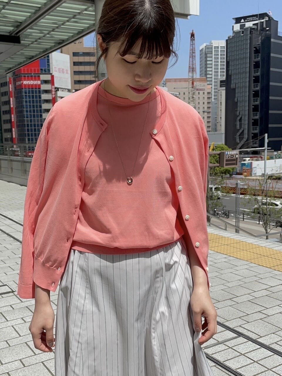 ベージュ系のタンクトップ、グレー系のスカートを着用したレディースの夏コーディネートの7枚目の写真