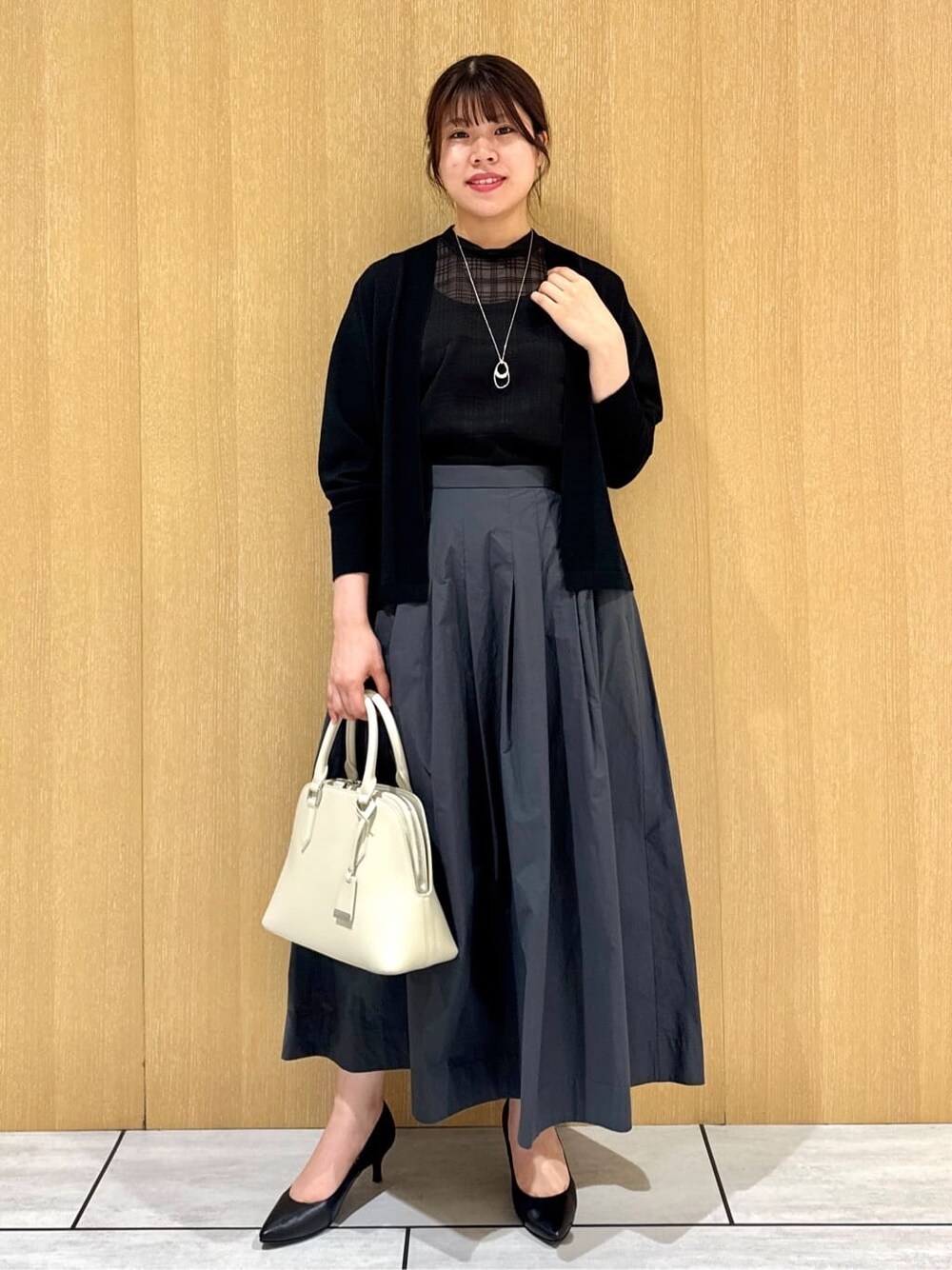 ブラック系のシャツ/ブラウス、グレー系のスカート、ブラック系のカーディガン/ボレロを着用したレディースの秋コーディネートの7枚目の写真