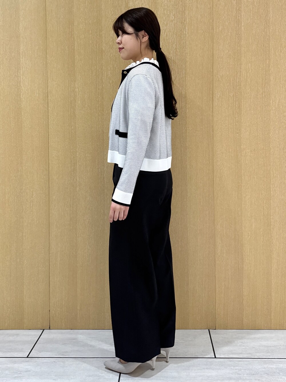 ブラック系のその他パンツ、ホワイト系のシャツ/ブラウス、ホワイト系のカーディガン/ボレロを着用したレディースの春コーディネートの2枚目の写真