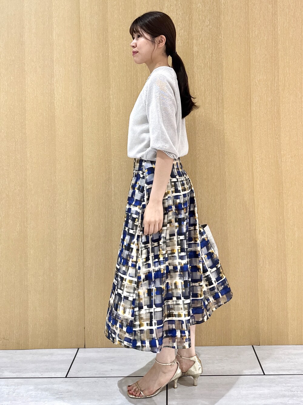 グレー系のニット/セーター、ホワイト系のタンクトップを着用したレディースの夏コーディネートの2枚目の写真
