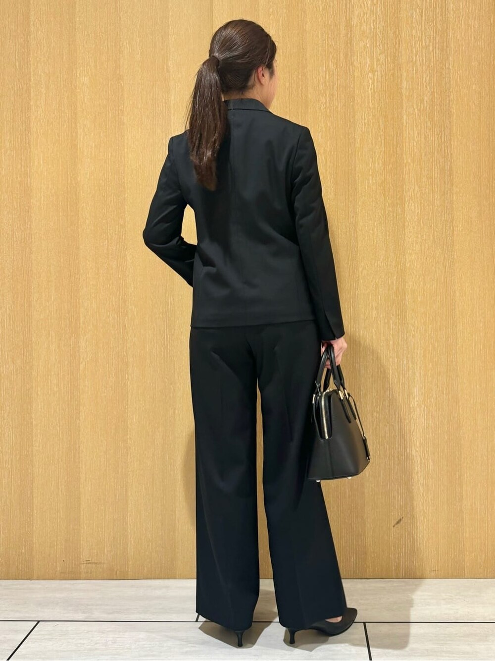 ブラック系のテーラードジャケット、ブラック系のその他パンツ、ブラック系のパンプスを着用したレディースの秋コーディネートの4枚目の写真
