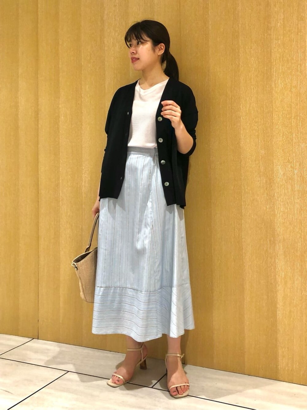 グレー系のニット/セーター、ブルー系のスカートを着用したレディースの夏コーディネートの6枚目の写真
