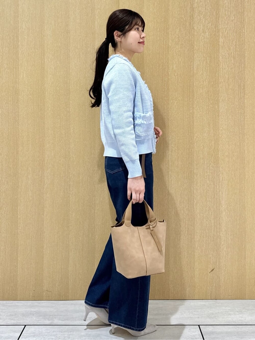 ベージュ系のトートバッグ、ブルー系のデニムパンツ、ホワイト系のシャツ/ブラウスを着用したレディースの春コーディネートの4枚目の写真