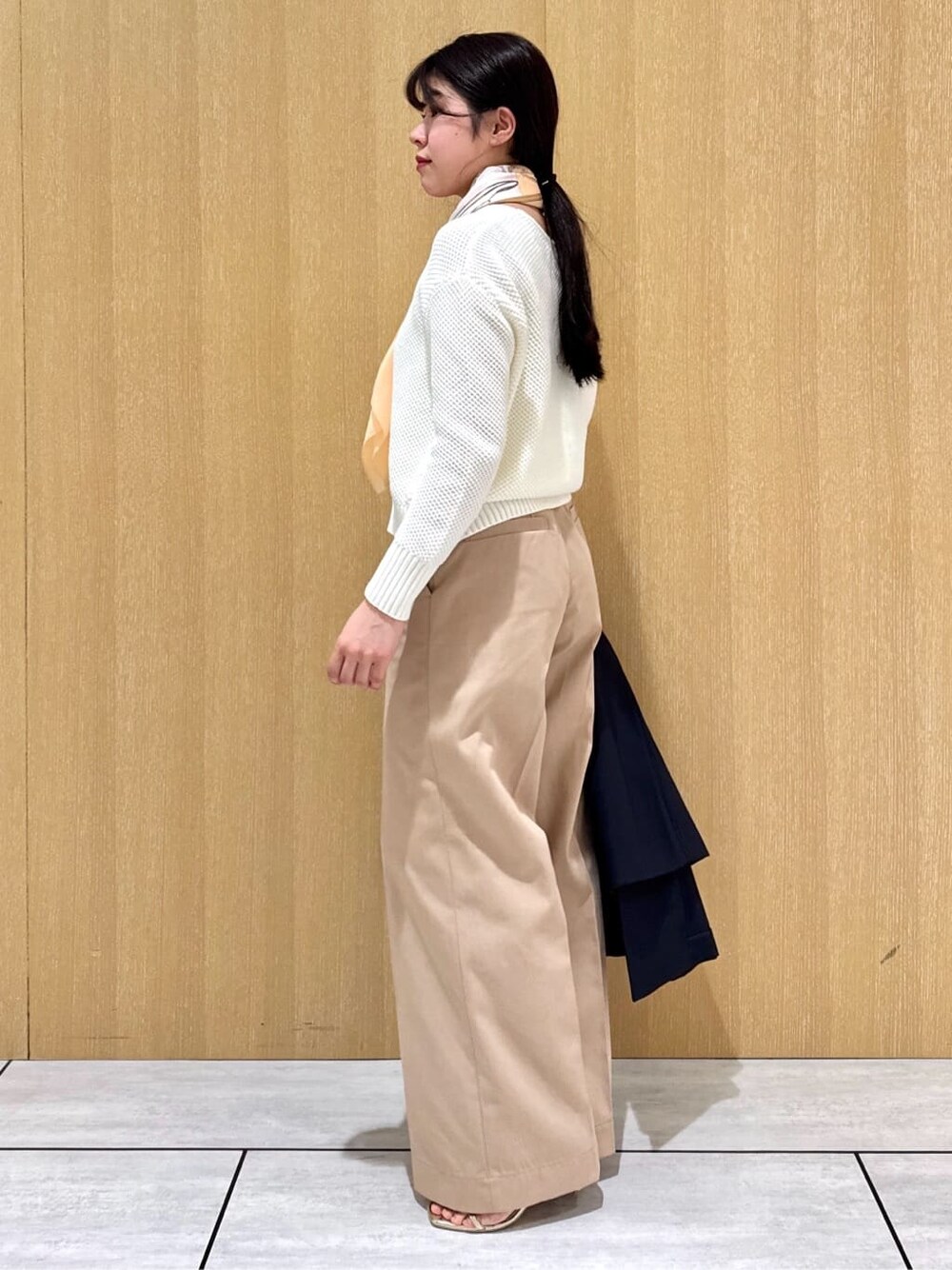 ホワイト系のニット/セーター、ベージュ系のその他パンツ、ブルー系のトレンチコートを着用したレディースの冬コーディネートの3枚目の写真