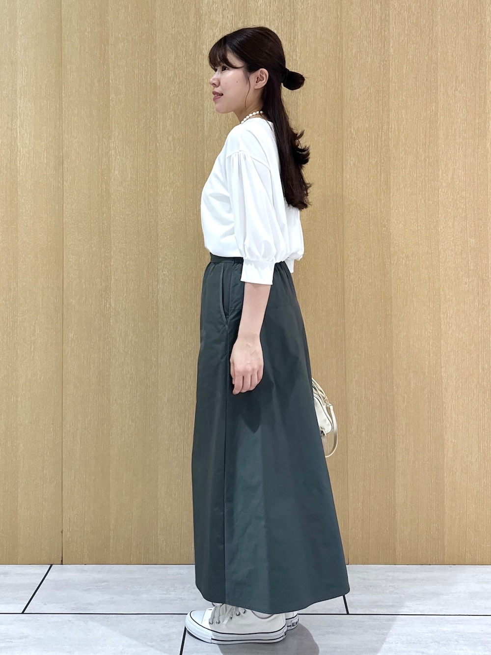 ホワイト系のTシャツ/カットソー、グリーン系のスカートを着用したレディースの秋コーディネートの4枚目の写真