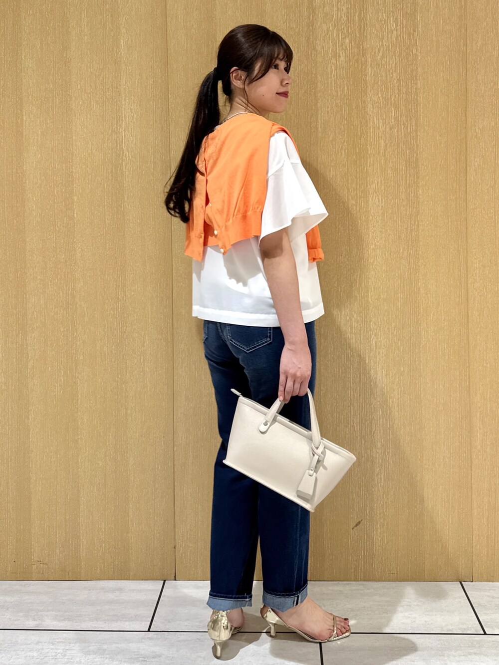 ホワイト系のシャツ/ブラウス、オレンジ系のカーディガン/ボレロ、ブルー系のデニムパンツを着用したレディースの夏コーディネートの4枚目の写真