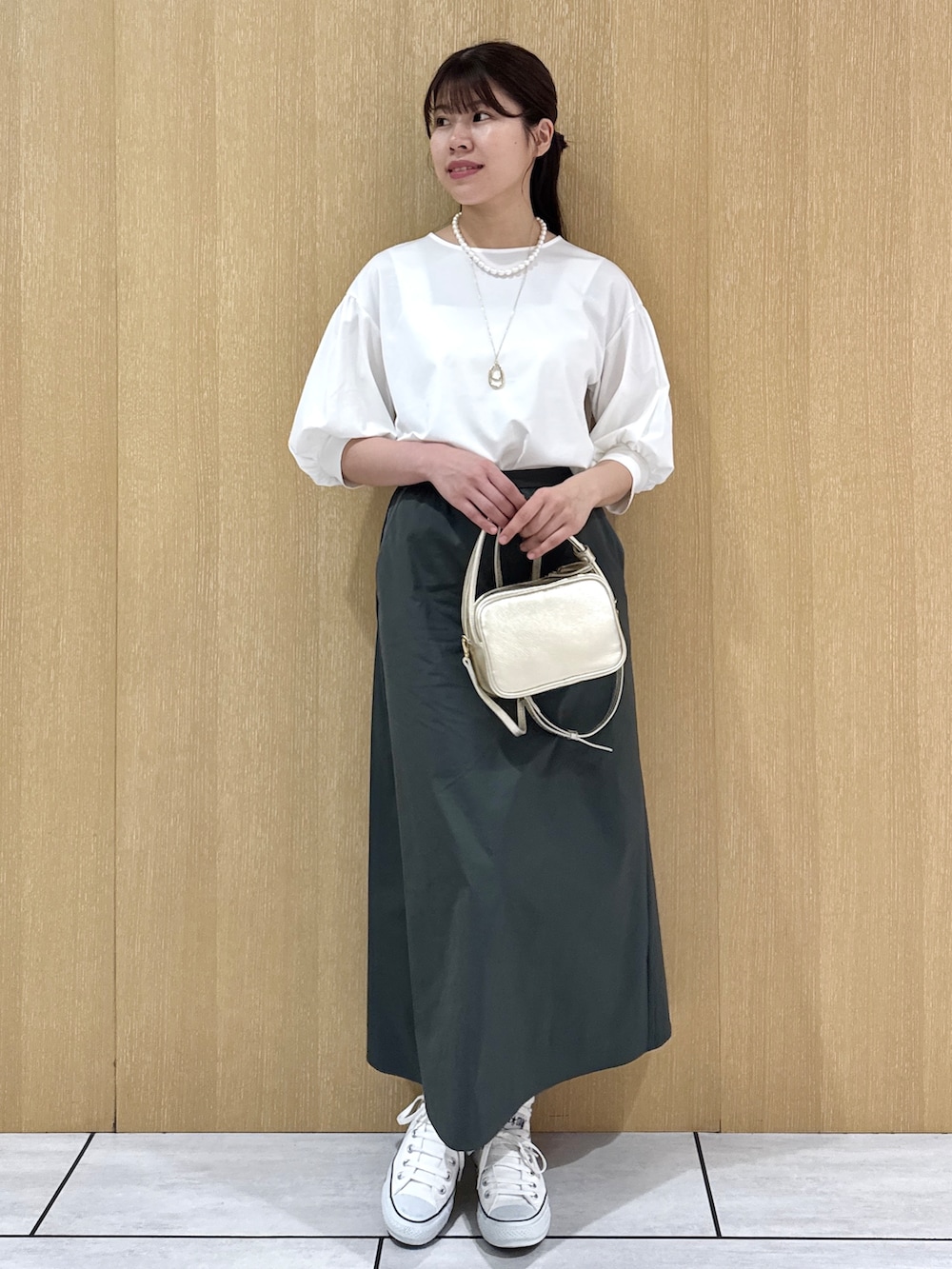 ホワイト系のTシャツ/カットソー、グリーン系のスカートを着用したレディースの秋コーディネートの9枚目の写真