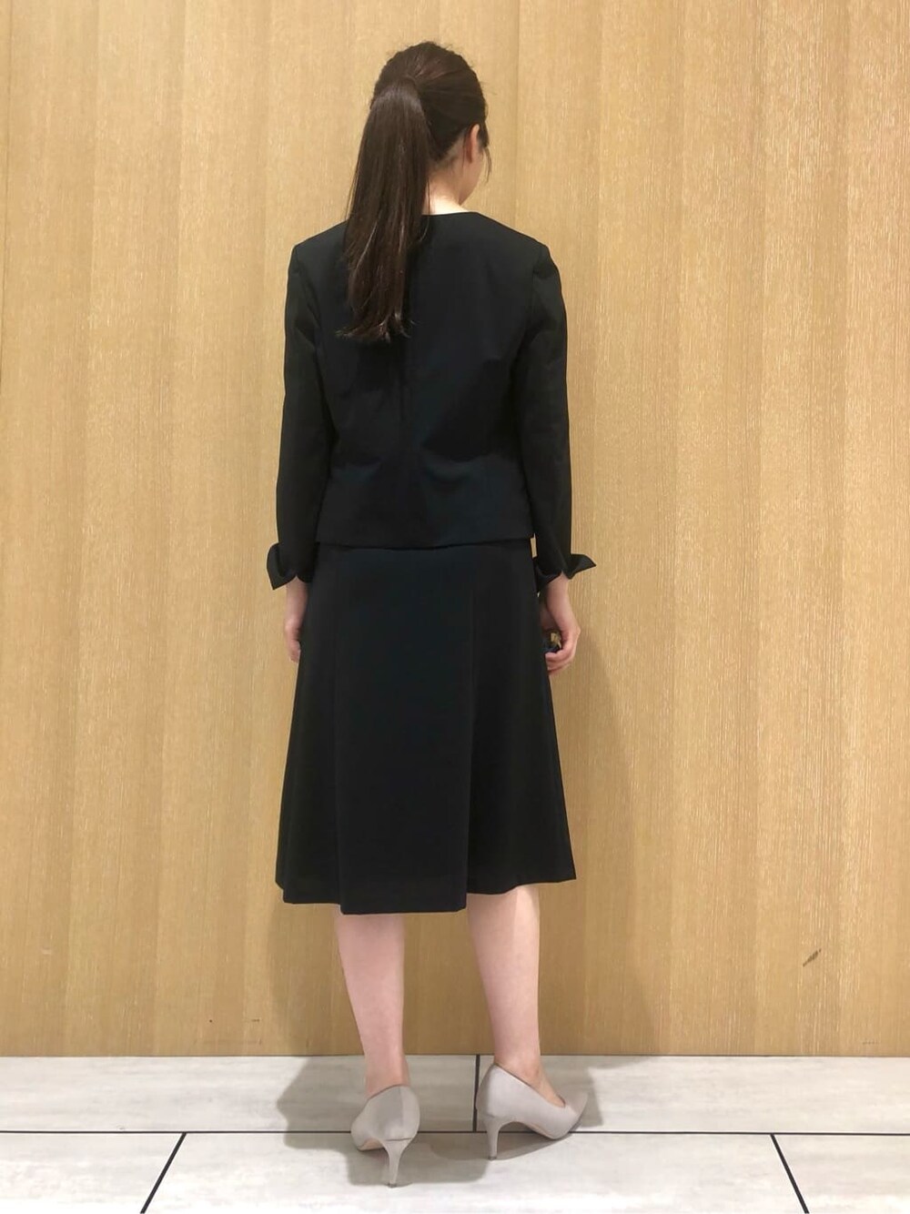ブラック系のノーカラージャケット、ブルー系のシャツ/ブラウス、ブラック系のスカートを着用したレディースの夏コーディネートの4枚目の写真