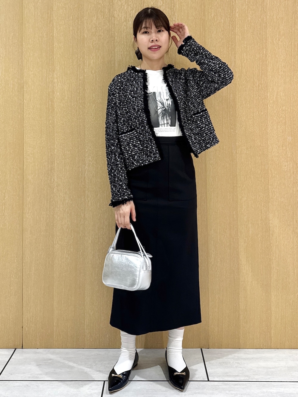 ブラック系のカーディガン/ボレロ、ホワイト系のTシャツ/カットソー、ブラック系のスカートを着用したレディースの秋コーディネートの2枚目の写真