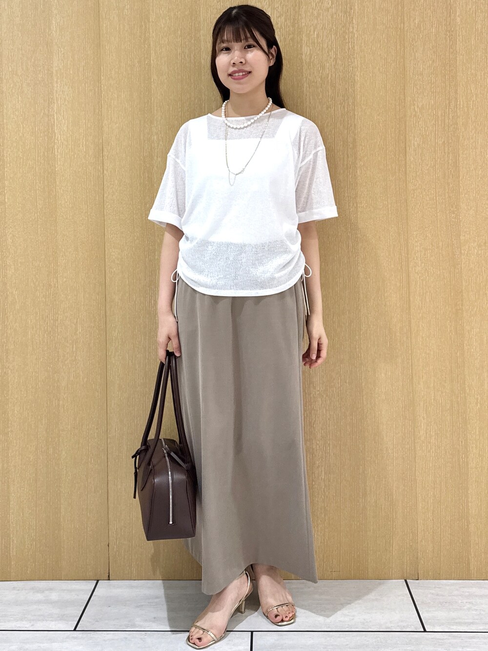 ホワイト系のTシャツ/カットソー、ホワイト系のタンクトップ、グリーン系のスカートを着用したレディースの夏コーディネートの9枚目の写真