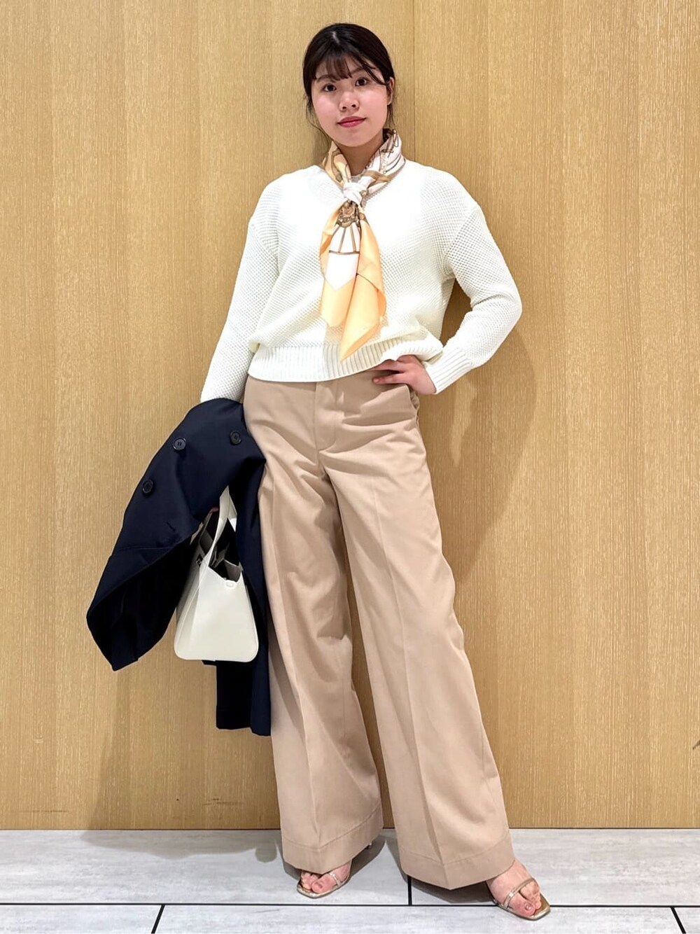 ホワイト系のニット/セーター、ベージュ系のその他パンツ、ブルー系のトレンチコートを着用したレディースの冬コーディネートの9枚目の写真