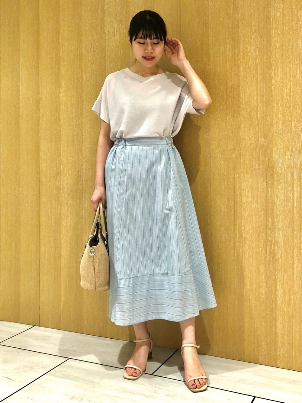 グレー系のニット/セーター、ブルー系のスカートを着用したレディースの夏コーディネートの2枚目の写真