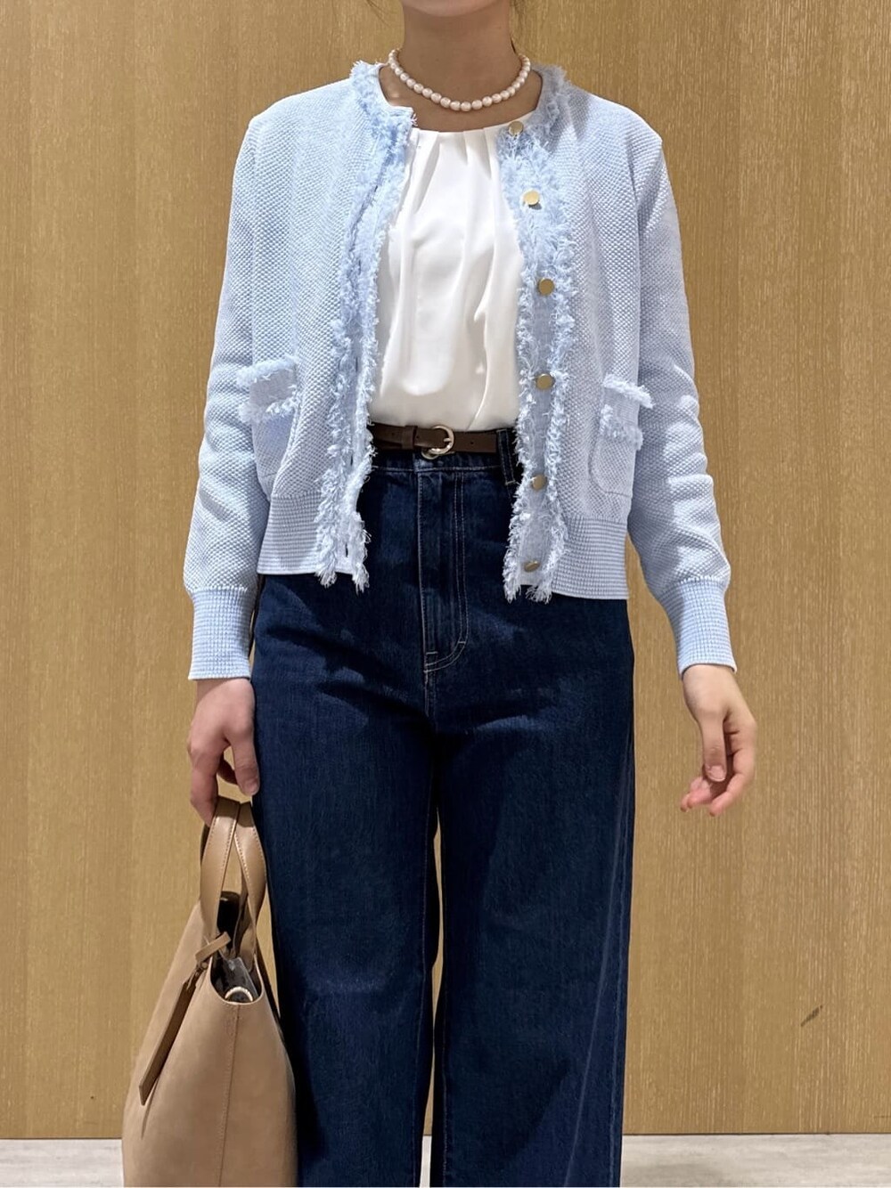 ベージュ系のトートバッグ、ブルー系のデニムパンツ、ホワイト系のシャツ/ブラウスを着用したレディースの春コーディネートの5枚目の写真