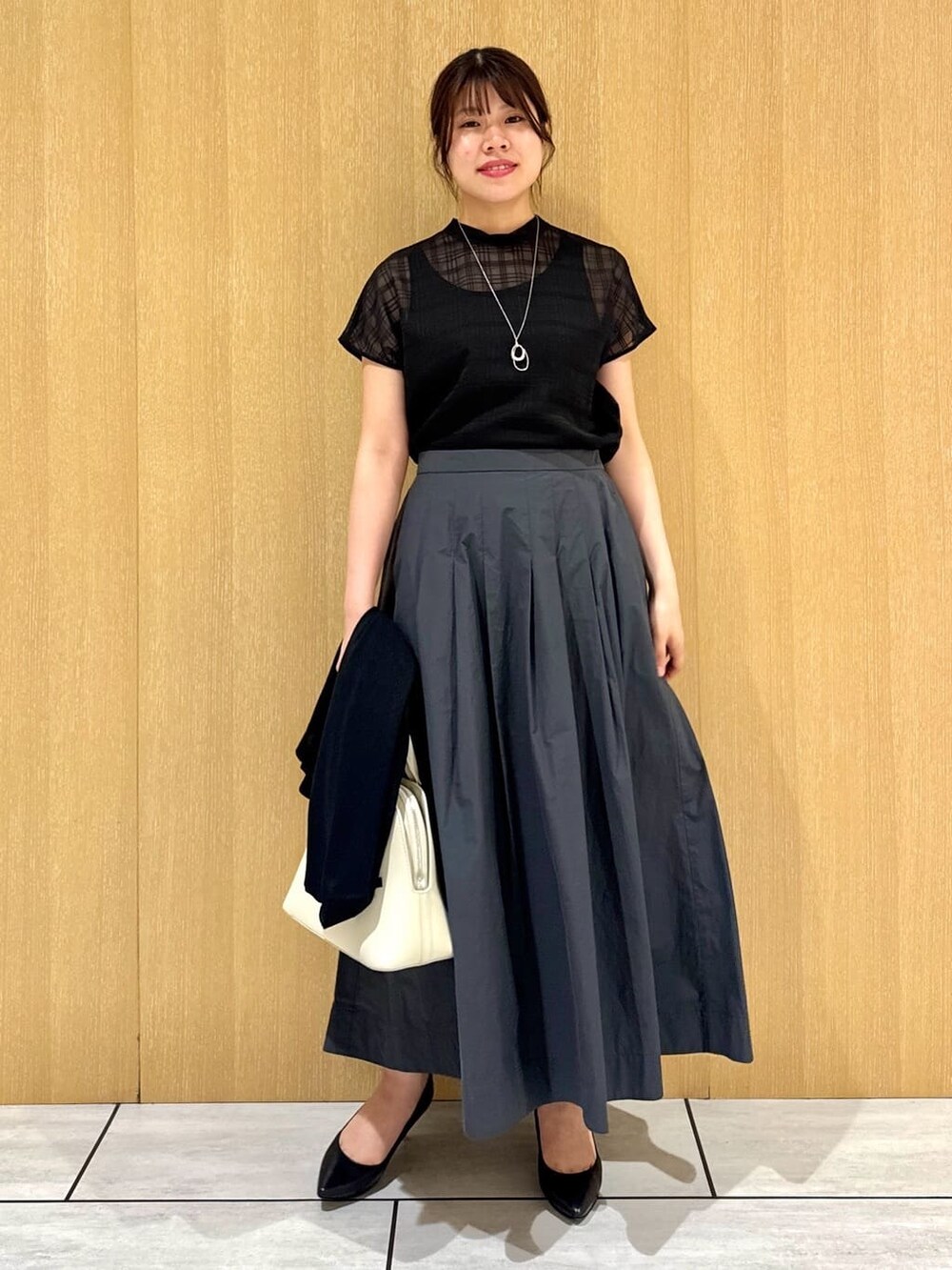 ブラック系のシャツ/ブラウス、グレー系のスカート、ブラック系のカーディガン/ボレロを着用したレディースの秋コーディネートの6枚目の写真
