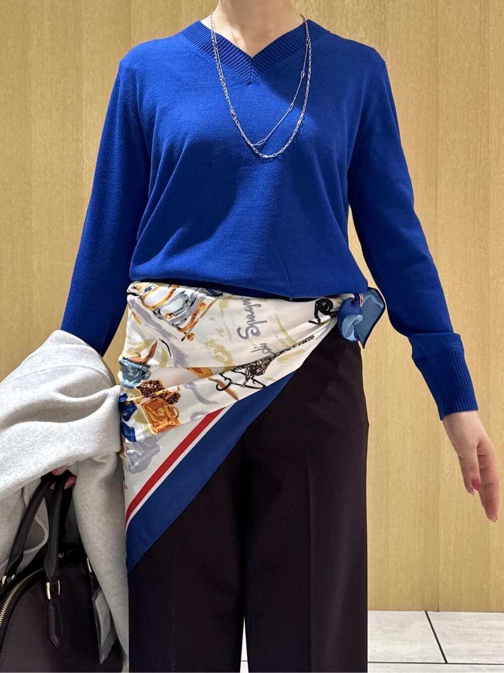 ブルー系のニット/セーター、ブラウン系のその他パンツ、ベージュ系のチェスターコートを着用したレディースの冬コーディネートの5枚目の写真