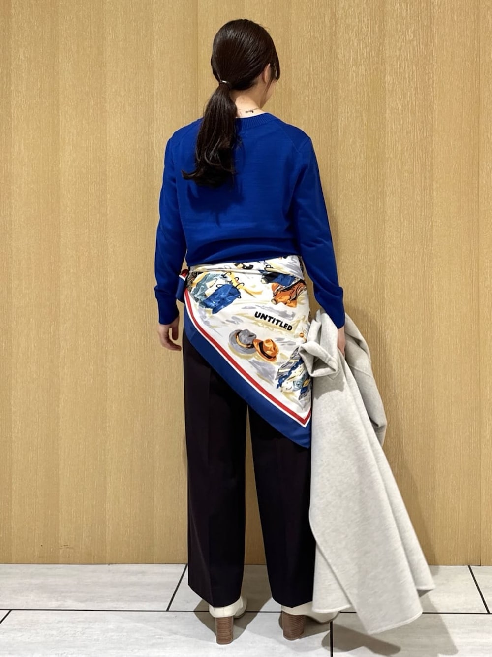 ブルー系のニット/セーター、ブラウン系のその他パンツ、ベージュ系のチェスターコートを着用したレディースの冬コーディネートの4枚目の写真