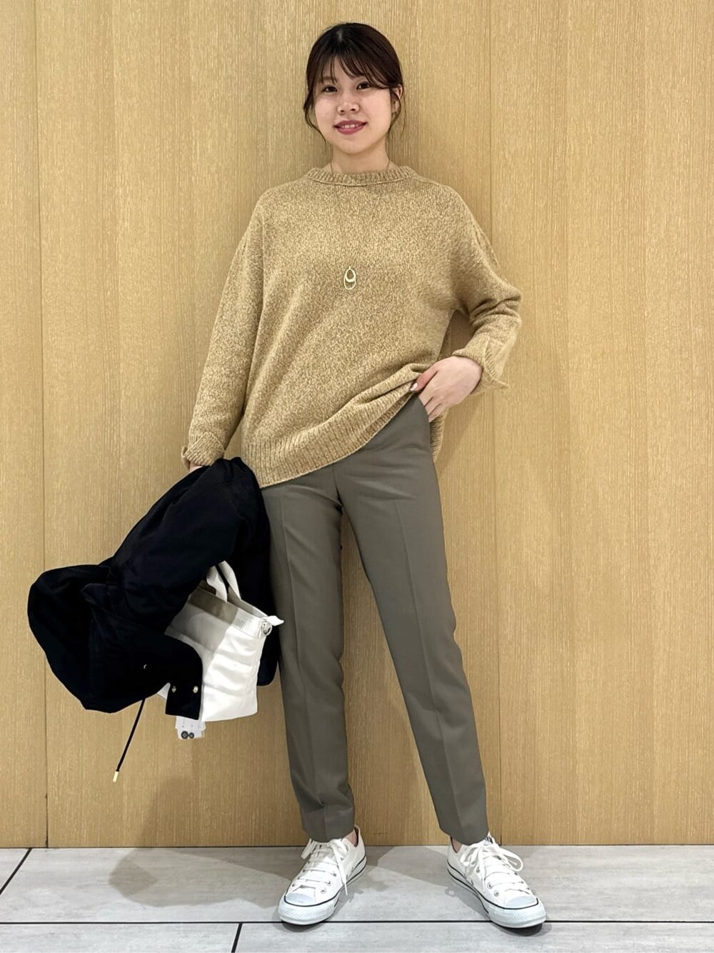 イエロー系のニット/セーター、ベージュ系のその他パンツ、ブラック系のブルゾンを着用したレディースの秋コーディネートの7枚目の写真