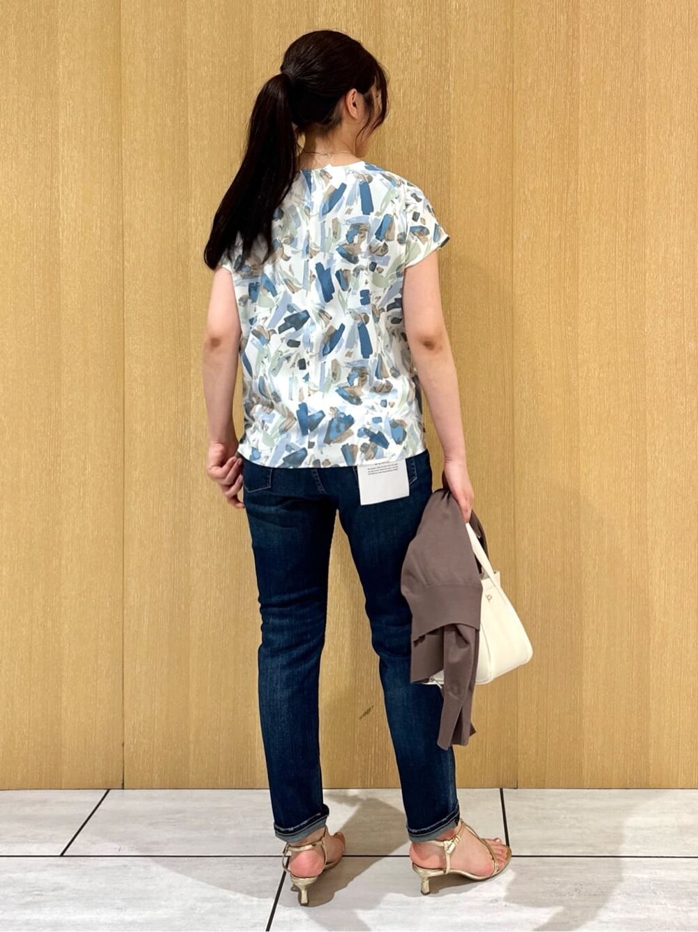 ブルー系のシャツ/ブラウス、ブルー系のデニムパンツ、ブラウン系のカーディガン/ボレロを着用したレディースの夏コーディネートの3枚目の写真