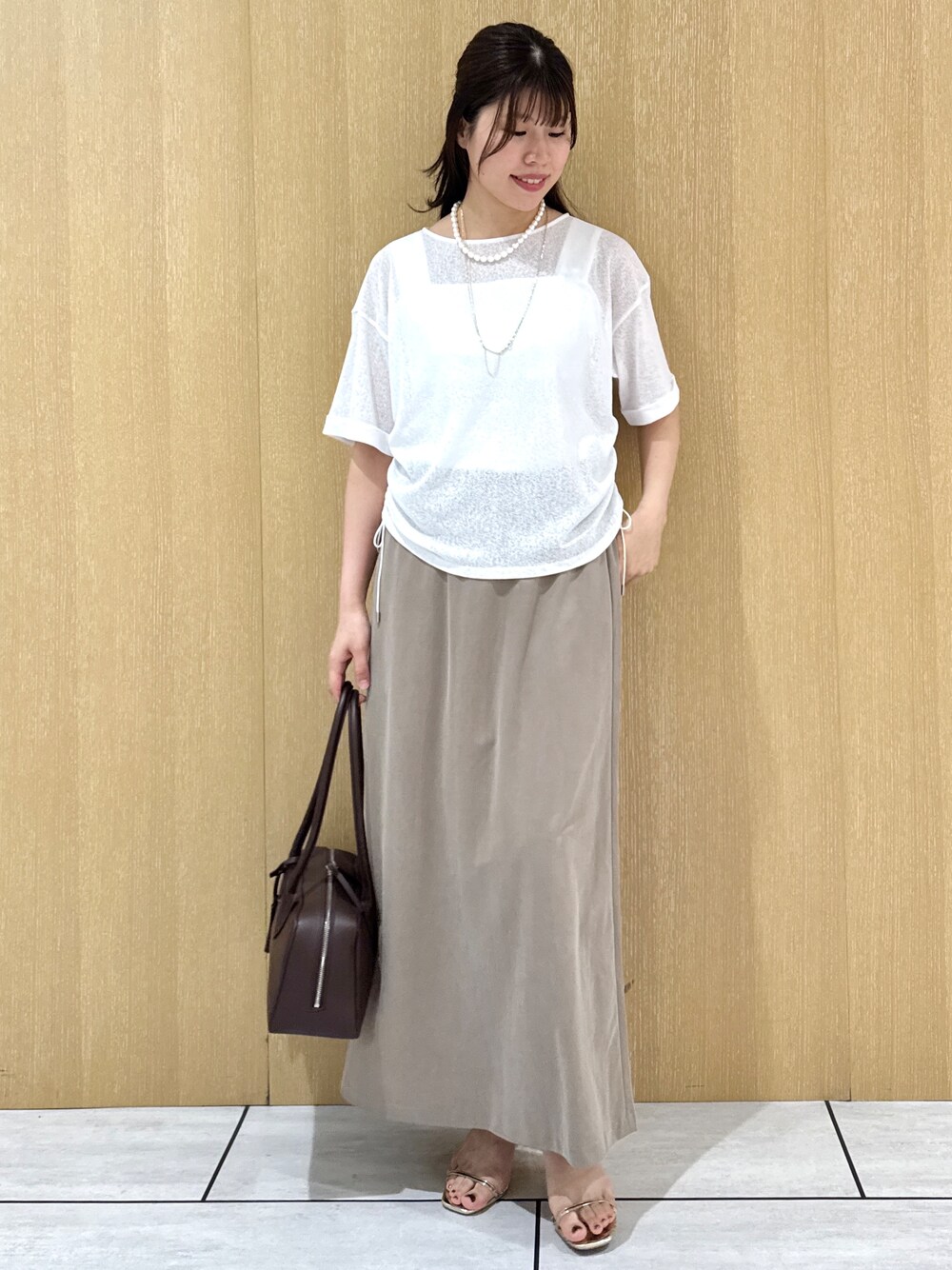 ホワイト系のTシャツ/カットソー、ホワイト系のタンクトップ、グリーン系のスカートを着用したレディースの夏コーディネートの10枚目の写真