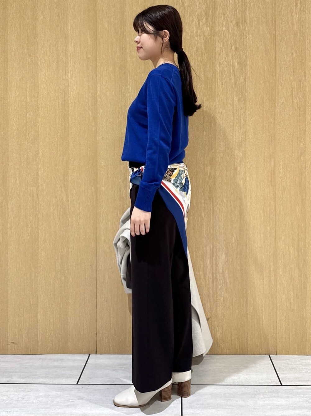 ブルー系のニット/セーター、ブラウン系のその他パンツ、ベージュ系のチェスターコートを着用したレディースの冬コーディネートの3枚目の写真