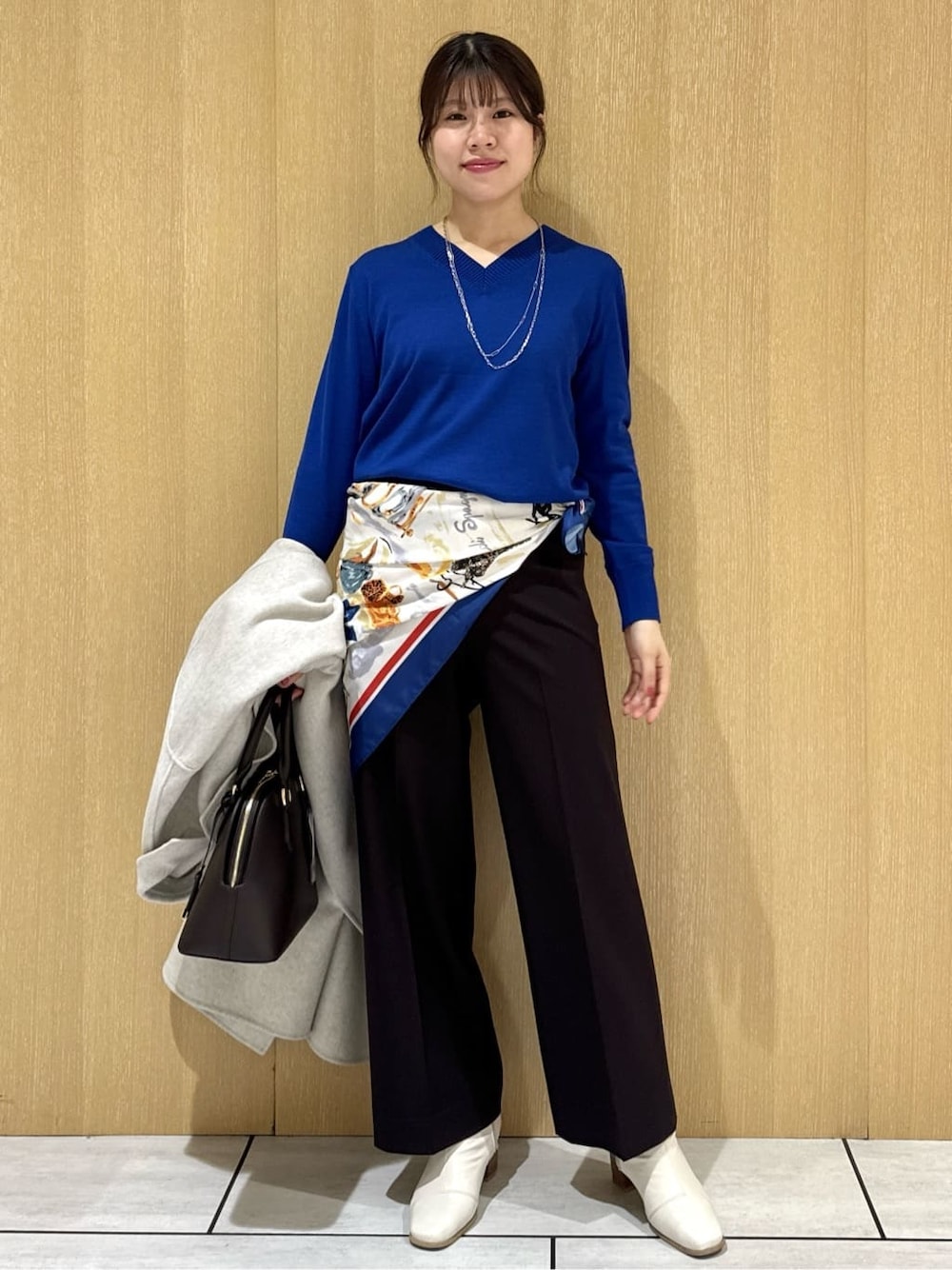 ブルー系のニット/セーター、ブラウン系のその他パンツ、ベージュ系のチェスターコートを着用したレディースの冬コーディネートの2枚目の写真