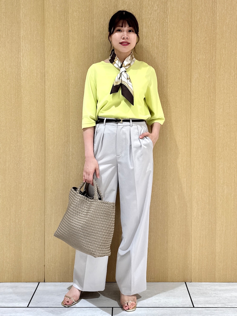 イエロー系のニット/セーター、ブラウン系のトートバッグ、グレー系のその他パンツを着用したレディースの春コーディネートの9枚目の写真