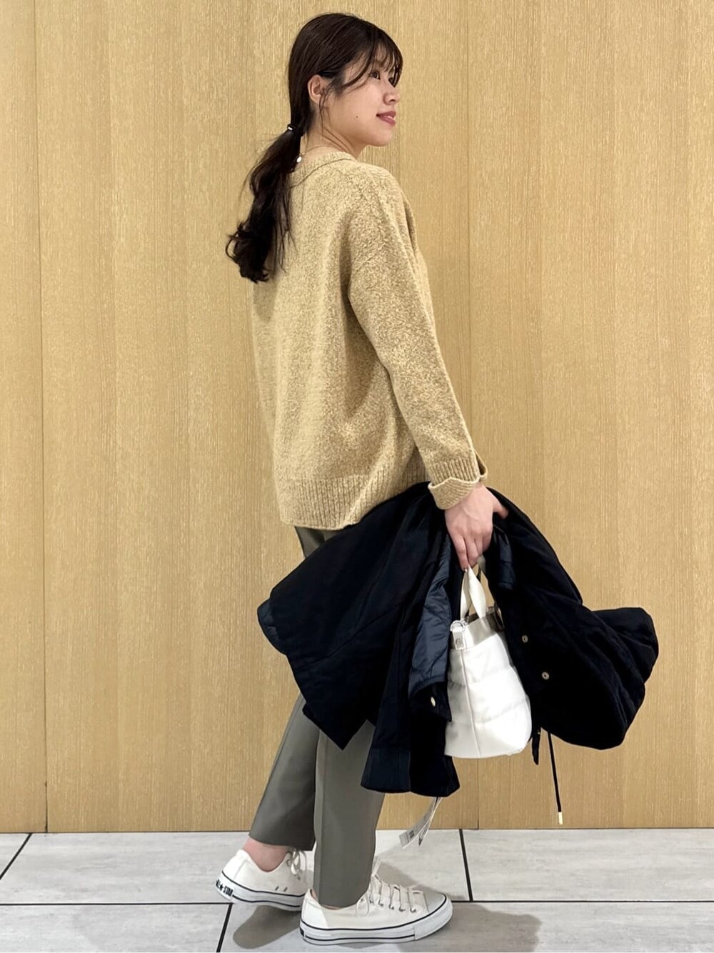 イエロー系のニット/セーター、ベージュ系のその他パンツ、ブラック系のブルゾンを着用したレディースの秋コーディネートの5枚目の写真
