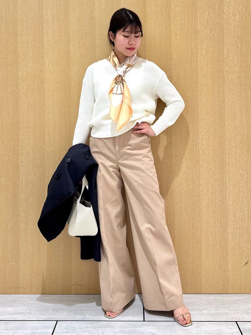 ホワイト系のニット/セーター、ベージュ系のその他パンツ、ブルー系のトレンチコートを着用したレディースの冬コーディネートの8枚目の写真