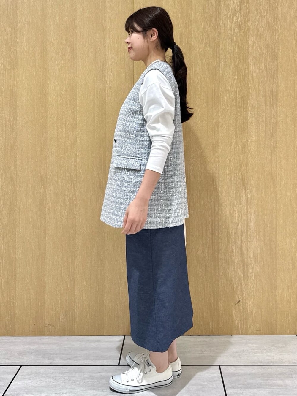グレー系のブルゾン、ホワイト系のTシャツ/カットソー、ブルー系のスカートを着用したレディースの春コーディネートの2枚目の写真