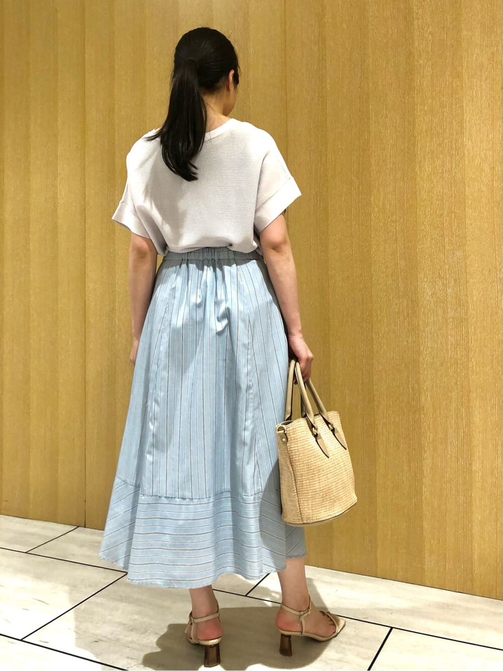グレー系のニット/セーター、ブルー系のスカートを着用したレディースの夏コーディネートの4枚目の写真