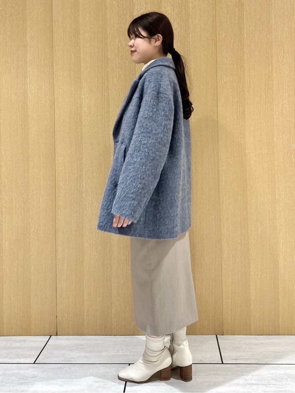 ブルー系のピーコート、ホワイト系のシャツ/ブラウス、ブラウン系のニット/セーターを着用したレディースの冬コーディネートの2枚目の写真