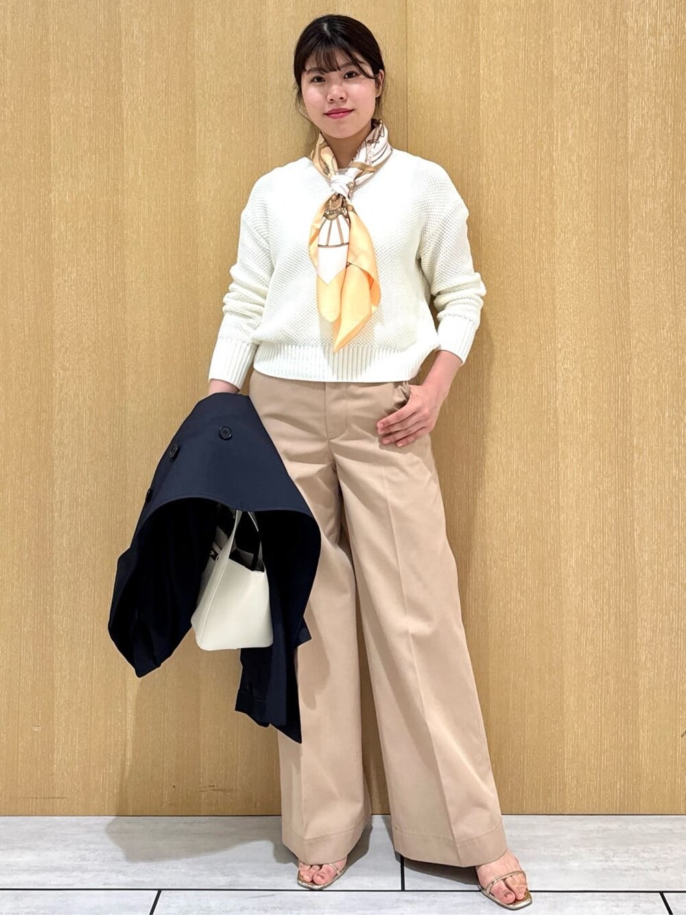 ホワイト系のニット/セーター、ベージュ系のその他パンツ、ブルー系のトレンチコートを着用したレディースの冬コーディネートの5枚目の写真