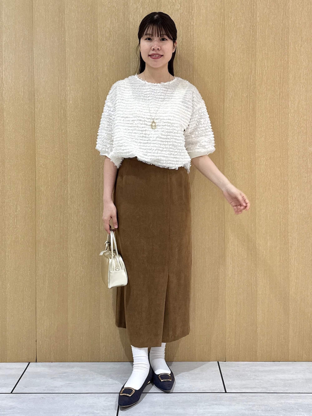 ホワイト系のTシャツ/カットソー、イエロー系のスカートを着用したレディースの秋コーディネートの5枚目の写真