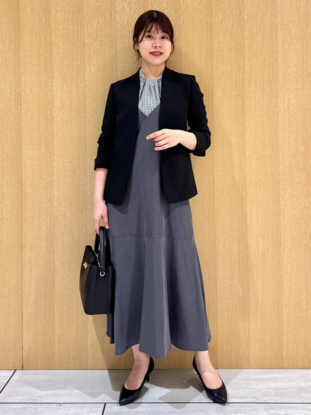 ブルー系のシャツ/ブラウス、グレー系のワンピース、ブラック系のノーカラージャケットを着用したレディースの夏コーディネートの7枚目の写真