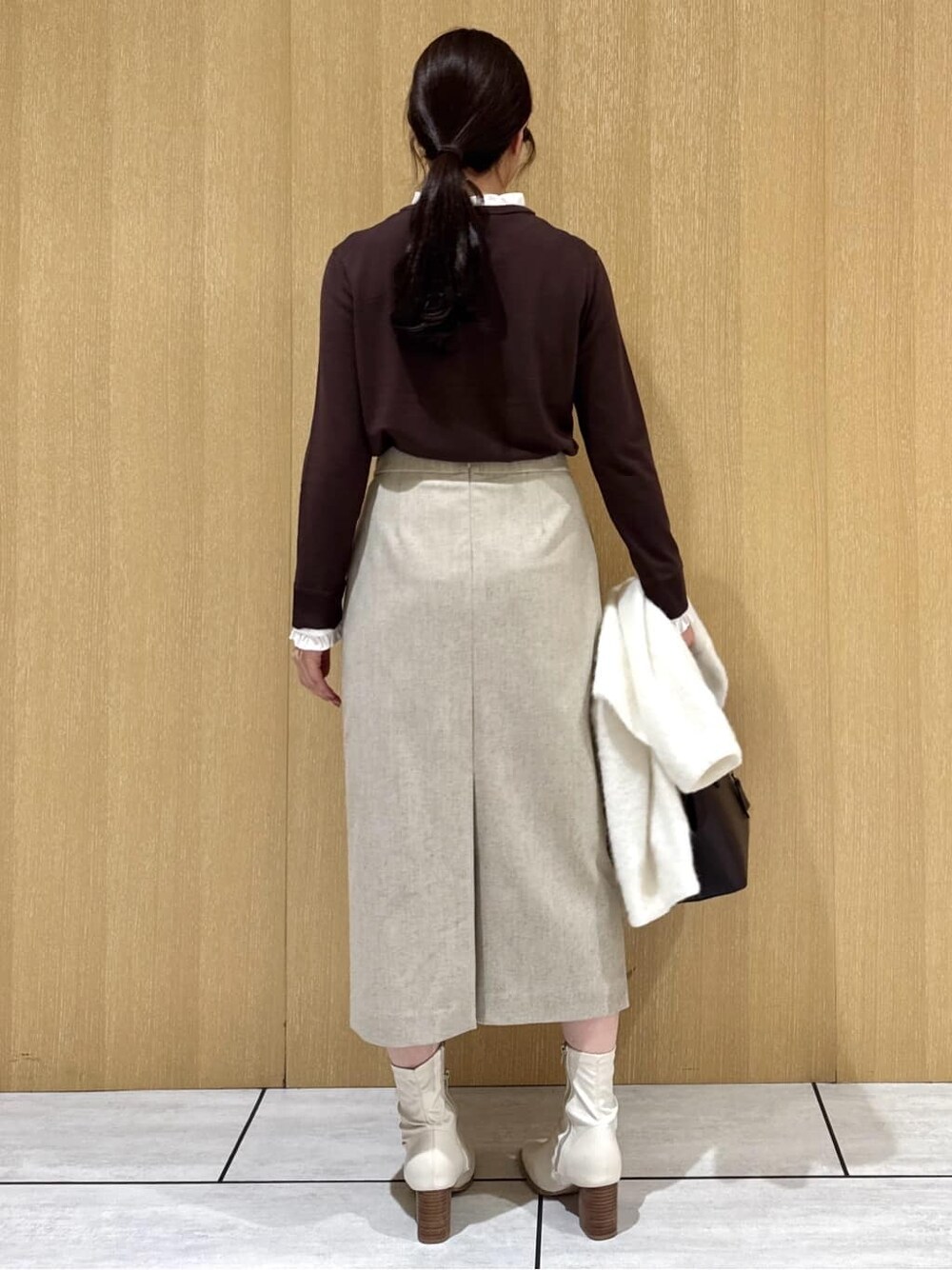 ブラウン系のニット/セーター、ベージュ系のスカート、ホワイト系のカーディガン/ボレロを着用したレディースの冬コーディネートの3枚目の写真