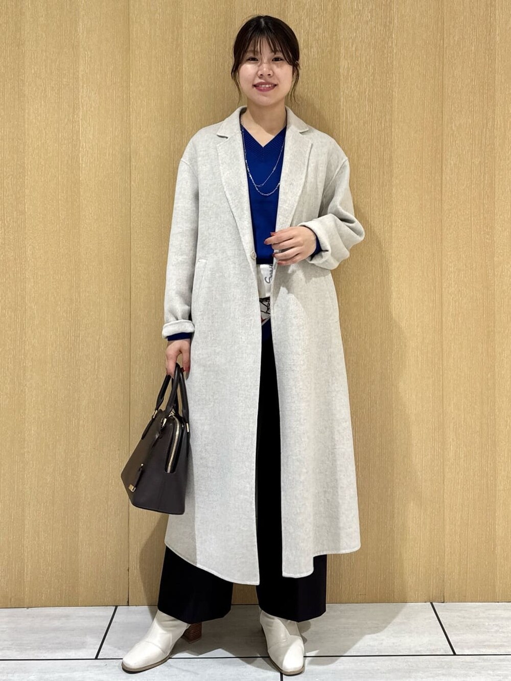 ブルー系のニット/セーター、ブラウン系のその他パンツ、ベージュ系のチェスターコートを着用したレディースの冬コーディネートの7枚目の写真
