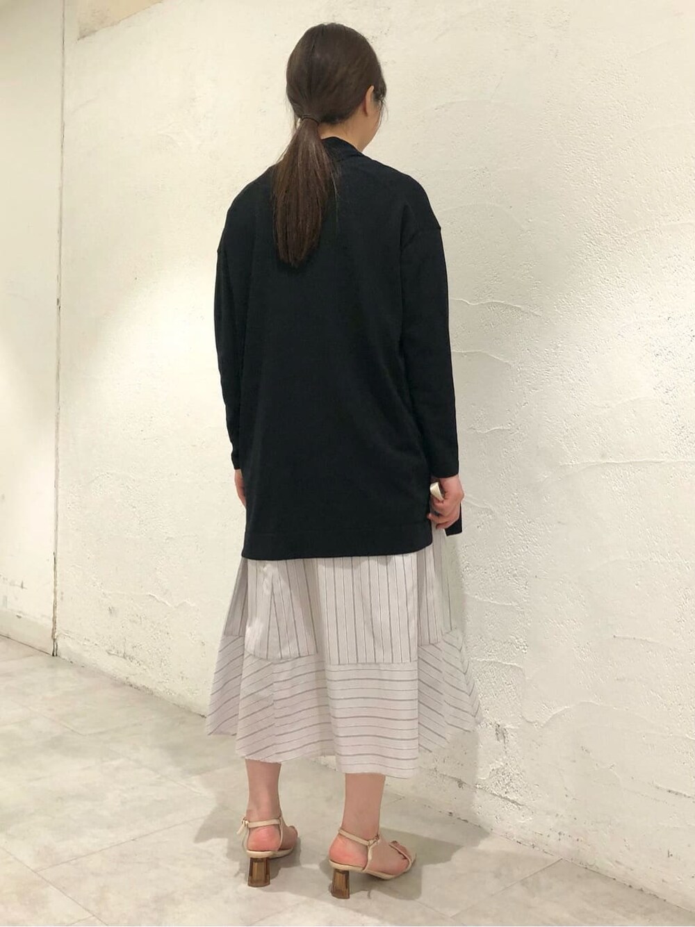 ブルー系のニット/セーター、グレー系のスカートを着用したレディースの夏コーディネートの3枚目の写真