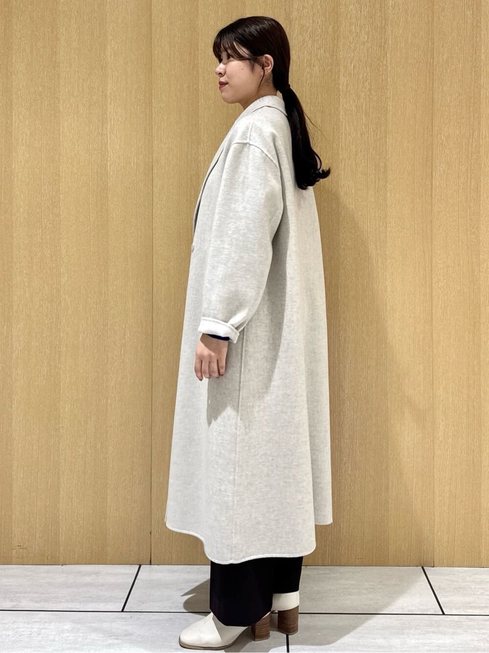 ブルー系のニット/セーター、ブラウン系のその他パンツ、ベージュ系のチェスターコートを着用したレディースの冬コーディネートの8枚目の写真