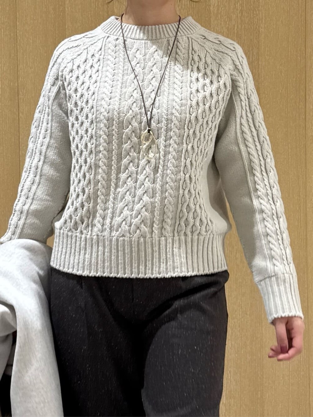 ベージュ系のニット/セーター、ブラウン系のその他パンツ、ベージュ系のチェスターコートを着用したレディースの冬コーディネートの5枚目の写真