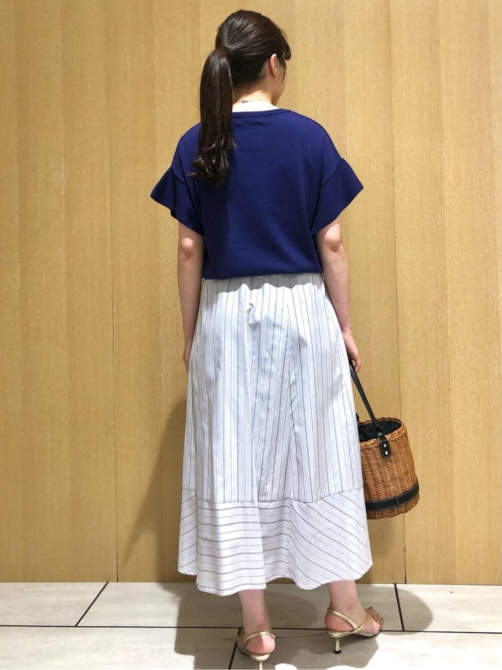 グレー系のスカートを着用したレディースの夏コーディネートの4枚目の写真
