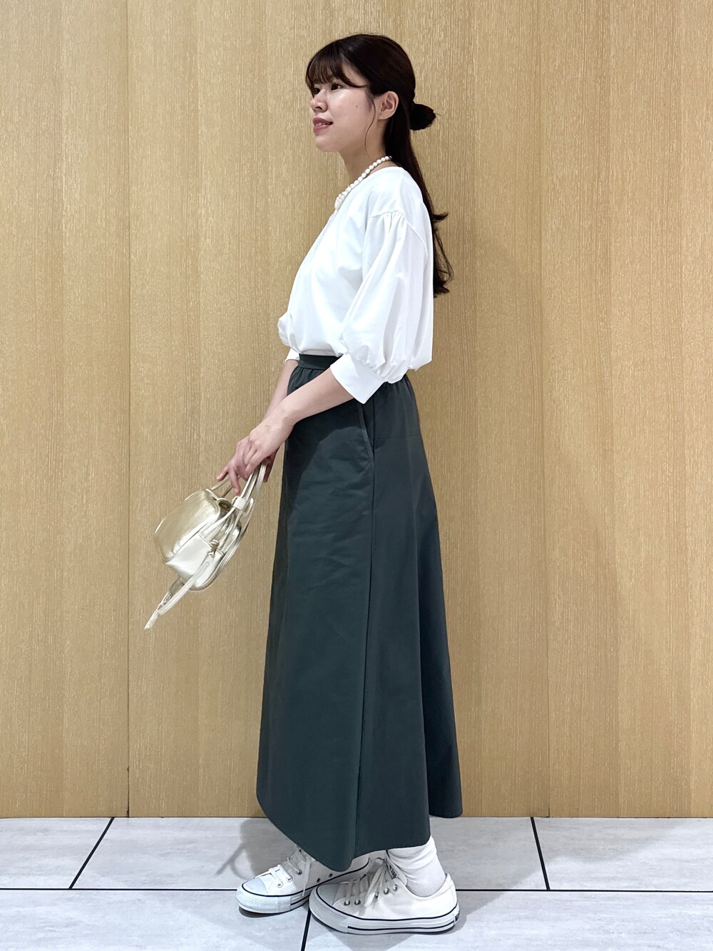 ホワイト系のTシャツ/カットソー、グリーン系のスカートを着用したレディースの秋コーディネートの3枚目の写真