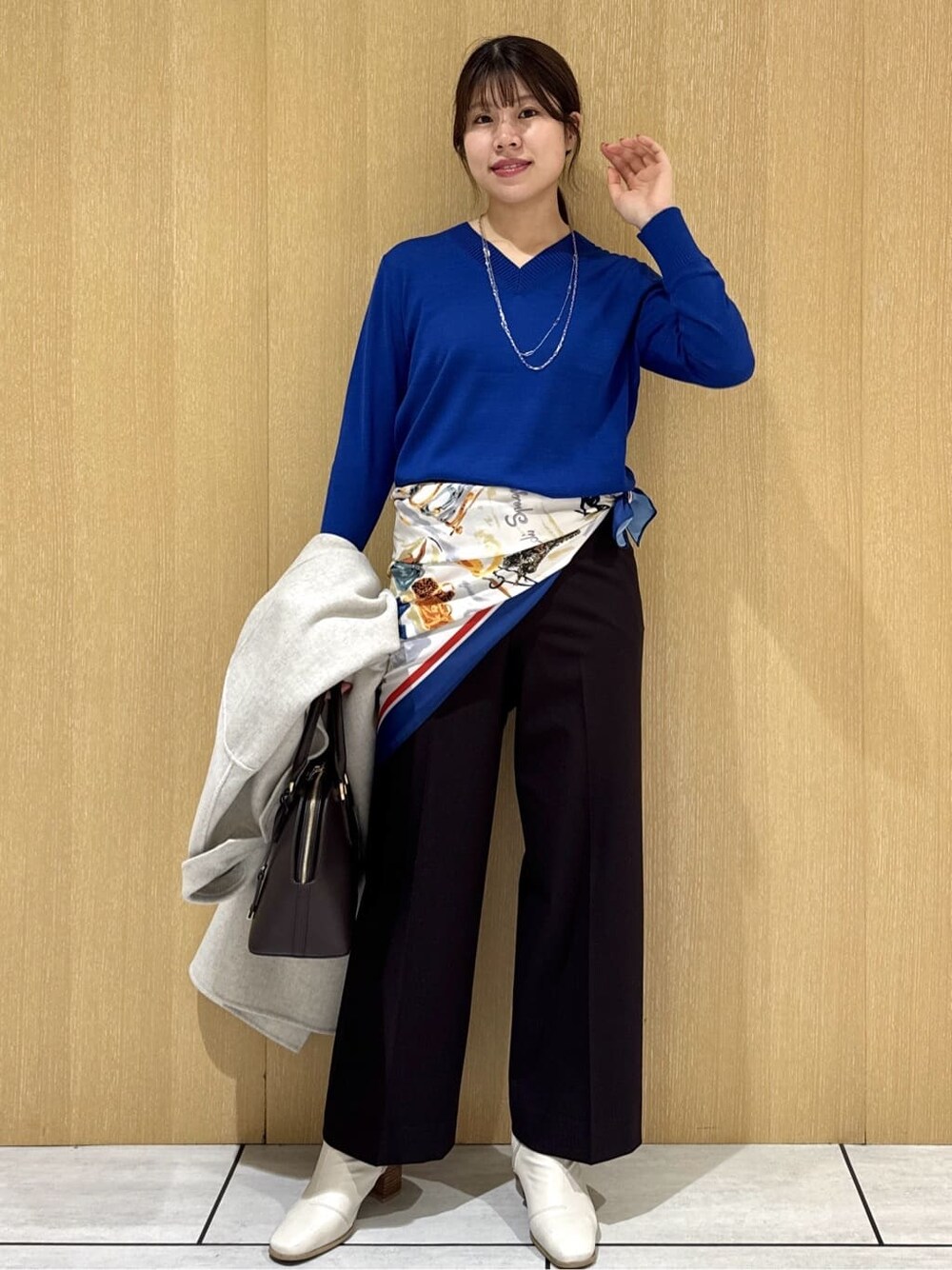ブルー系のニット/セーター、ブラウン系のその他パンツ、ベージュ系のチェスターコートを着用したレディースの冬コーディネートの10枚目の写真