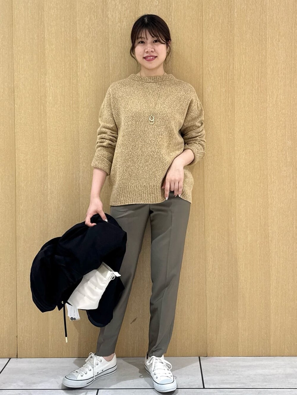 イエロー系のニット/セーター、ベージュ系のその他パンツ、ブラック系のブルゾンを着用したレディースの秋コーディネートの8枚目の写真