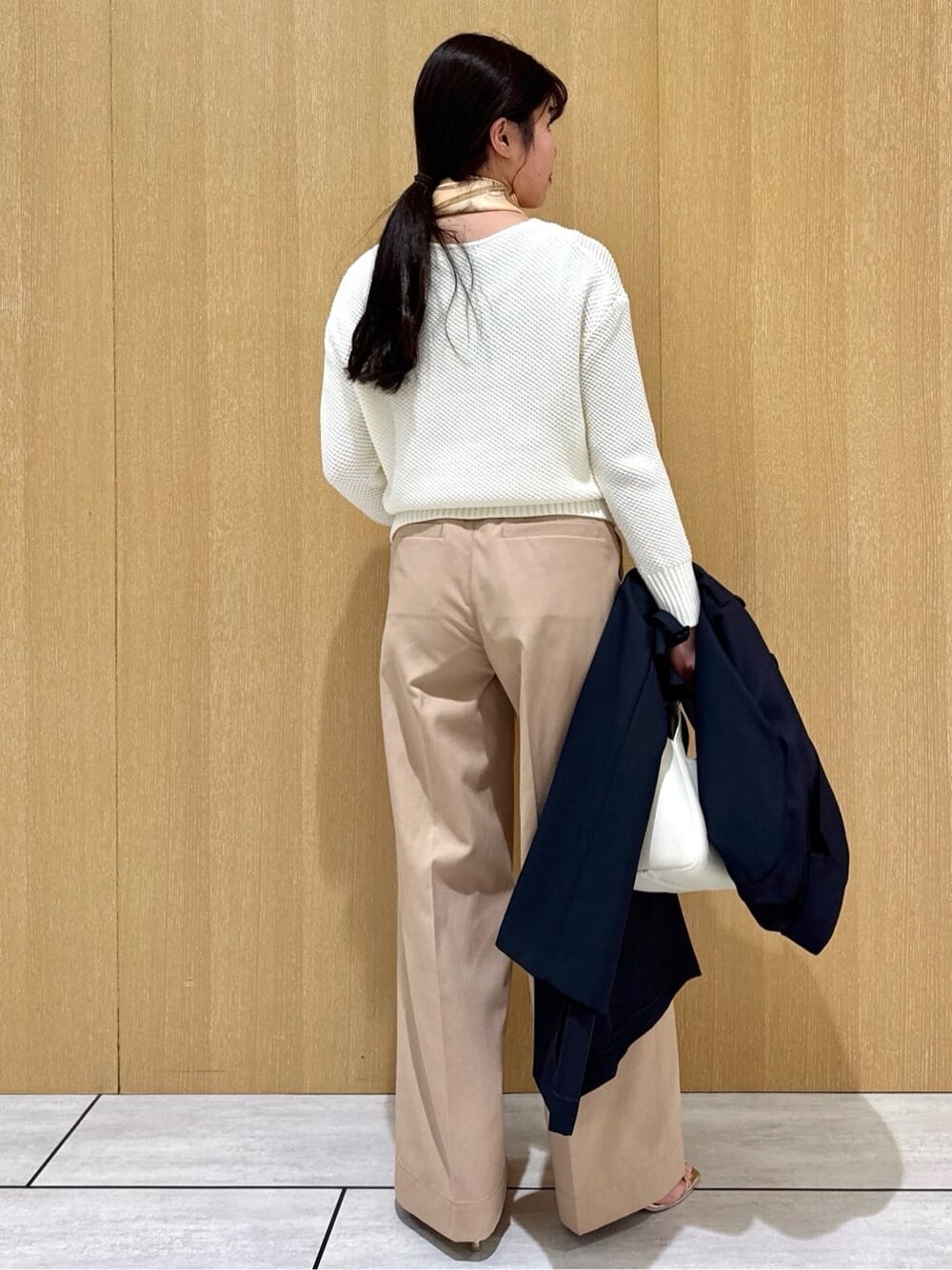 ホワイト系のニット/セーター、ベージュ系のその他パンツ、ブルー系のトレンチコートを着用したレディースの冬コーディネートの4枚目の写真