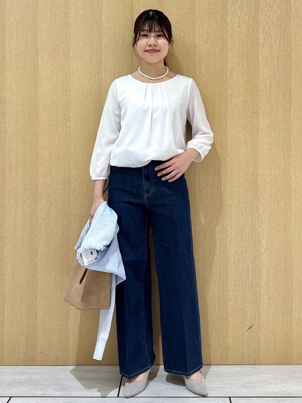 ベージュ系のトートバッグ、ブルー系のデニムパンツ、ホワイト系のシャツ/ブラウスを着用したレディースの春コーディネートの7枚目の写真