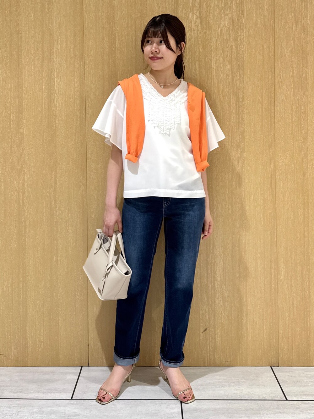 ホワイト系のシャツ/ブラウス、オレンジ系のカーディガン/ボレロ、ブルー系のデニムパンツを着用したレディースの夏コーディネートの6枚目の写真